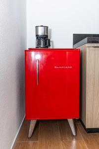 Un refrigerador rojo con un café encima. en Guaja 745 - Apartamento Bento, en Belo Horizonte
