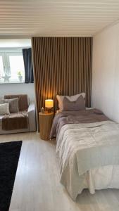 FälhultにあるSmåländsk stugidyll med vedeldad tunna & pizzaugnのベッドとソファのある寝室