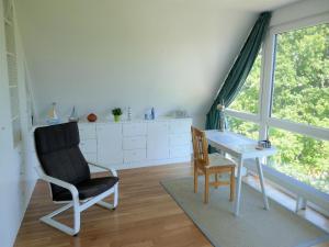 KopendorfにあるFerienhaus in Fehmarn OT Köpendorfの椅子、デスク、窓が備わる客室です。