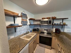 a kitchen with a sink and a stove at 7-204 - Kama'ole Sands in Wailea