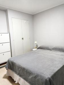 1 dormitorio blanco con 1 cama y vestidor en Departamento Momó, en San Miguel de Tucumán