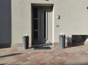two vases with flowers in them in front of a building at Attic House Mountain Lake Iseo Hospitality in Bossico +21 photos