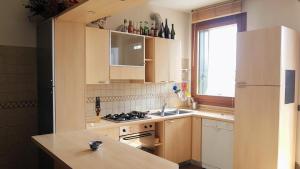 Una cocina con gabinetes de madera y un fregadero. en Vicino ad Agripolis fra Venezia e Padova in un piccolo paese - Maya, en Legnaro