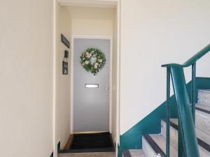 a hallway with a door with a wreath on it at Tree Tops View in Windermere