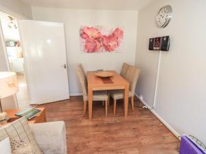 a dining room with a table and chairs and a clock at Tree Tops View in Windermere