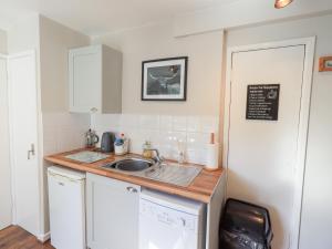 a small kitchen with a sink and a counter at Tree Tops View in Windermere