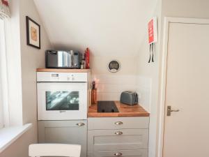 a small kitchen with a stove and a microwave at Tree Tops View in Windermere
