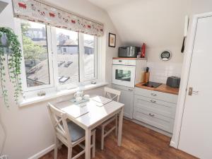 a kitchen with a white table and a window at Tree Tops View in Windermere