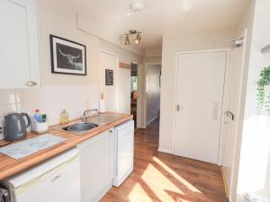 a kitchen with white cabinets and a sink at Tree Tops View in Windermere