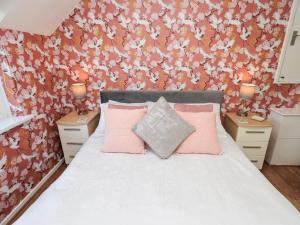 a bedroom with a bed with pink pillows at Tree Tops View in Windermere