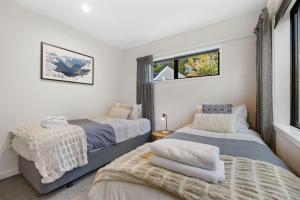 una camera da letto con due letti e una finestra di Viscount Haven - Lake Views a Queenstown