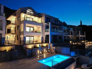 a villa with a swimming pool at night at Solmare Loft Suite in Nikiana