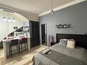 a bedroom with a bed and a small kitchen at Casa Kate Juchitán in Juchitán de Zaragoza