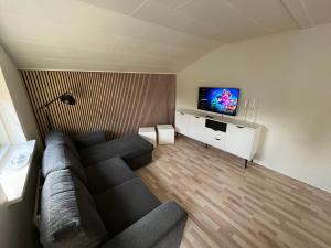 a living room with a couch and a flat screen tv at Billund Sol Center House in Billund