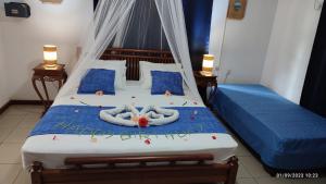 a bedroom with a bed with two people in towels at La Digue Ylang Ylang in La Digue