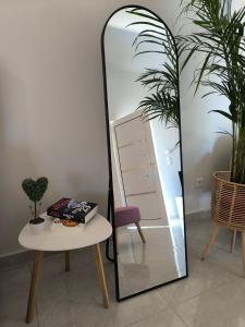 a mirror sitting next to a table and a chair at Araucaria studio Manis in Mesochórion +16 photos