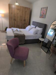 a bedroom with a large bed and a chair at Araucaria studio Manis in Mesochórion