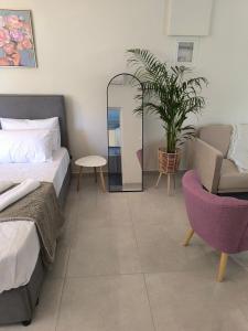 a bedroom with a bed and a chair and a mirror at Araucaria studio Manis in Mesochórion