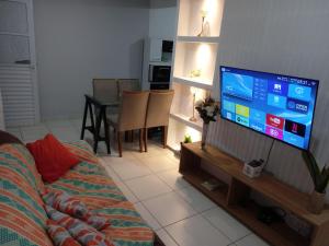 un salon avec un canapé et une télévision dans l'établissement Apartamento com área de lazer completa!, à Valparaíso de Goiás