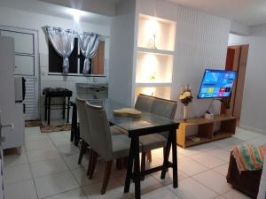 une cuisine et une salle à manger avec une table et une télévision dans l'établissement Apartamento com área de lazer completa!, à Valparaíso de Goiás 1 autre photo