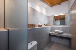 a bathroom with a toilet and a sink at Kentrikon Rooms III & Mint House in Limenaria
