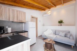 a kitchen and a living room with a couch at Kentrikon Rooms III & Mint House in Limenaria +32 photos