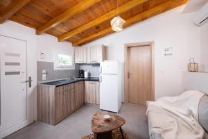 a kitchen with a white refrigerator and a table at Kentrikon Rooms III & Mint House in Limenaria
