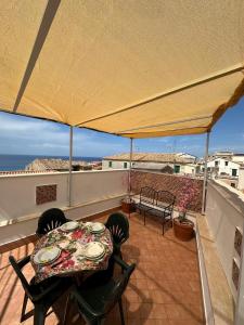 a patio with a table and chairs on a balcony at Affaccio sul Mare Attico in Tropea
