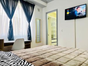 a bedroom with a bed and a television on the wall at Flat en Av Granados in Quito