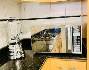 a kitchen with a blender and a microwave on a counter at Flat en Av Granados in Quito +31 photos
