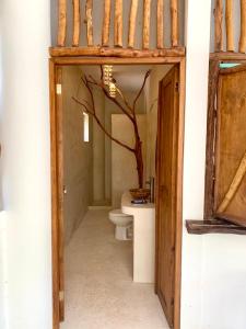 a bathroom with a toilet and a tree in it at The Jungle House, Sacbé in Playa del Carmen