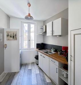 cocina con armarios blancos y suelo de madera en Historic Center and Port of Vannes, en Vannes