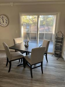 a dining room with a table and chairs and a clock at Lazy E Country Cozy in Edmond +21 photos