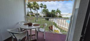 Un balcón con mesa y sillas y vista al mar. en Appartement F2 Vue Piscine, en Saint-François