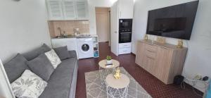 Una sala de estar con un sofá y una cocina. en Appartement F2 Vue Piscine, en Saint-François