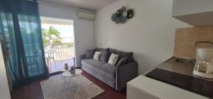 una sala de estar con un sofá y una mesa en Appartement F2 Vue Piscine, en Saint-François