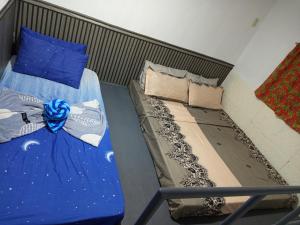 a bedroom with two beds with blue pillows at Sarah's Garden BnB & Spa SARAH'S HOUSE RENTAL in Clarin