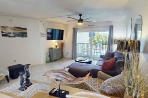 a living room with a couch and a ceiling fan at 105 - Caprice Resort in St. Pete Beach