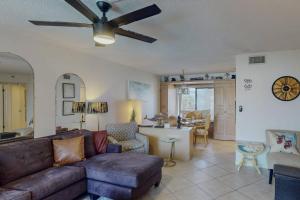 a living room with a couch and a ceiling fan at 105 - Caprice Resort in St. Pete Beach +42 photos