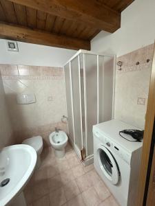 a bathroom with a washing machine and a toilet at Affaccio sul Mare Attico in Tropea