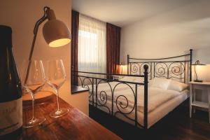 1 dormitorio con 1 cama y 2 copas de vino en Vinařství & Vinařský dům Petratur, en Blatnice