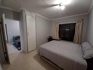 a bedroom with a bed and a window and a television at Sanctuary at Waterfall in Midrand