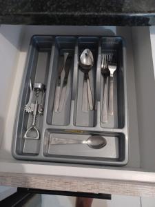 a tray with utensils in a kitchen sink at Sanctuary at Waterfall in Midrand