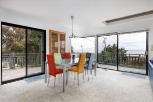 a dining room with a table and chairs and windows at Snug Harbor in Cambria