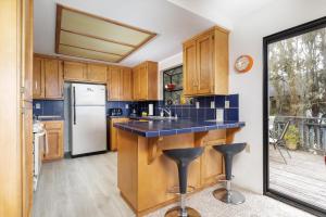 a kitchen with wooden cabinets and a blue counter top at Snug Harbor in Cambria +15 photos