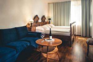 Una sala de estar con un sofá, una cama y una mesa. en Vinařství & Vinařský dům Petratur, en Blatnice