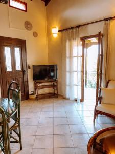 a living room with a television and a tiled floor at Mantis Home in Syvota +39 photos