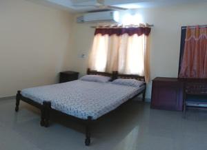 a bedroom with a bed and a window with curtains at Alapatt Homestay in Alleppey