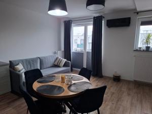 a living room with a table and chairs and a couch at Trimare in Sztutowo