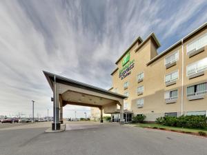 - un bâtiment d'hôtel avec un auvent en face dans l'établissement Holiday Inn Express Hotel & Suites - Edmonton International Airport by IHG, à Nisku